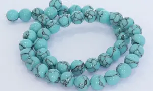 Eine Kette aus hellblauen, runden Perlen mit dunklen Äderungen, die an den Himmel erinnern. Der türkis schimmert in der Sonne.