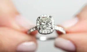 Ein funkelnder Verlobungsring mit einem großen Diamanten im Zentrum, umgeben von kleineren Steinen. Die Reinheit der Diamanten ist beeindruckend, fast wie eine Tabelle der Perfektion.