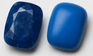 Zwei blaue Steine nebeneinander. Einer ist facettiert und tiefblau, der andere glatt und leuchtend. Ihre Bedeutung liegt in ihrer Schönheit und Vielfalt.