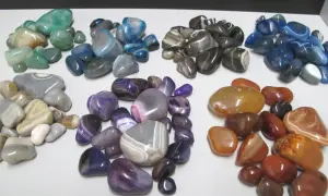 Bunte achat heilstein Steine in verschiedenen Farben und Mustern liegen auf einer weißen Fläche.
