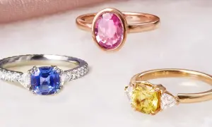 Drei Ringe mit Edelsteinen: ein blauer Saphir, ein gelber Saphir und ein rosa Saphir. Die Bedeutung von rosa Saphir steht für Liebe und Mitgefühl.