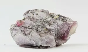 Ein schuppiger, lila-grauer Lepidolith-Stein mit glänzenden Oberflächen und einem kleinen, rosa Kristall.
