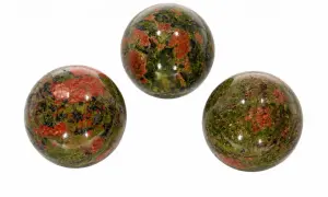 Drei polierte Kugeln aus Unakit, einem Stein mit Epidot-Einschlüssen, zeigen ein faszinierendes Muster aus Grün und Rot.