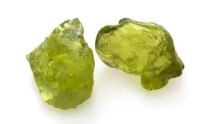 Zwei rohe Peridot-Kristalle in leuchtendem Grün. Ihre natürliche **Peridot Wirkung** soll angeblich das Herz öffnen und positive Energie fördern.