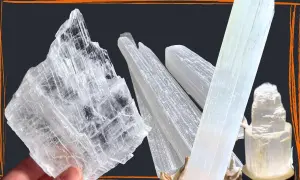 Mehrere transparente, säulenförmige Kristalle, die wie Eis aussehen. Ein großer, flacher Selenit Stein wird von einer Hand gehalten.