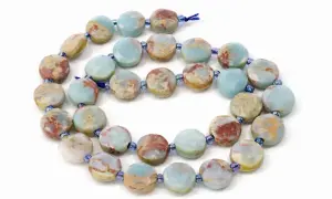 Kette aus flachen, facettierten Scheiben aus grauem Jaspis mit blauen und roten Einschlüssen. Die Wirkung dieses Steins soll beruhigend sein.