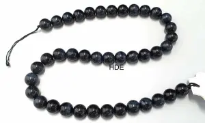 Eine Kette aus dunklen, glänzenden Perlen, die an das Auge eines Falken erinnern.