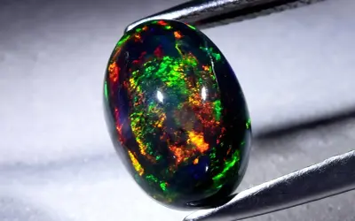Ein faszinierender schwarzer Opal mit lebendigen Farbspielen von Grün, Rot und Gelb. Seine Wirkung ist magisch.
