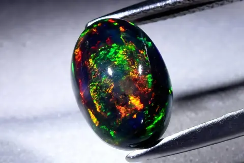 Ein faszinierender schwarzer Opal mit lebendigen Farbspielen von Grün, Rot und Gelb. Seine Wirkung ist magisch.