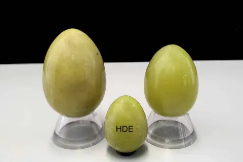 Drei polierte Serpentinsteine in Eiform, die die Bedeutung von Heilung und Erneuerung symbolisieren.