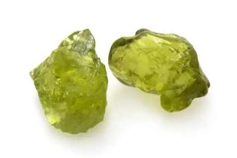 Zwei rohe Peridot-Kristalle in leuchtendem Grün. Ihre natürliche **Peridot Wirkung** soll angeblich das Herz öffnen und positive Energie fördern.