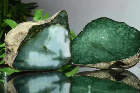 Zwei rohe Jade-Stücke, eines hellblau-grün, das andere tiefgrün. Die Jade-Name-Bedeutung spiegelt sich in ihrer Schönheit wider.