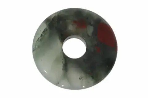 Ein runder Anhänger aus Heliotrop mit roten Flecken, der die beruhigende Wirkung des Steins symbolisiert.