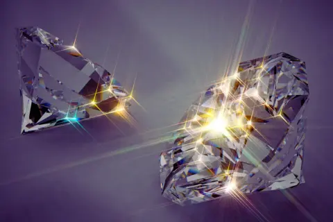 Zwei funkelnde, geschliffene Diamanten auf violettem Hintergrund. Die Lichtreflexionen deuten auf synthetische Diamanten Nachteile hin, da sie künstlich erzeugt werden.