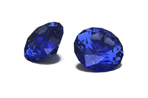 Zwei facettierte Saphire in tiefem Blau, die ihre Brillanz zeigen. Der Saphir steht für Weisheit und Treue.