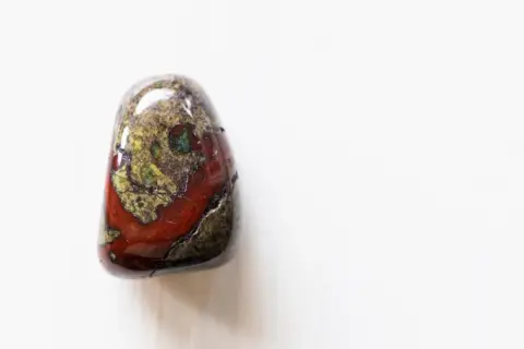 Ein polierter Stein mit roten und grünen Mustern, der an Drachenblut erinnert. Seine spirituelle Bedeutung liegt in Stärke und Schutz.