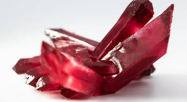 Rote Kristalle, die an einen Rubin erinnern. Die Bedeutung von Rubin liegt in Leidenschaft und Vitalität.