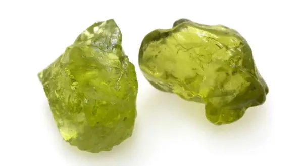 Zwei rohe Peridot-Kristalle in leuchtendem Grün. Ihre natürliche **Peridot Wirkung** soll angeblich das Herz öffnen und positive Energie fördern.