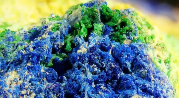Nahaufnahme von Azurit und Malachit, die wie eine Miniaturlandschaft mit tiefblauen und smaragdgrünen Mineralien aussieht.