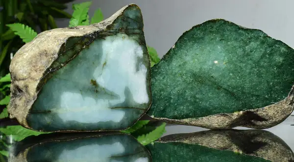 Zwei rohe Jade-Stücke, eines hellblau-grün, das andere tiefgrün. Die Jade-Name-Bedeutung spiegelt sich in ihrer Schönheit wider.