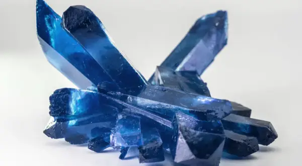 Ein Cluster tiefblauer Kristalle, die an gefrorene Eisspitzen erinnern. Die Bedeutung eines blauen Steins wird oft mit Ruhe und Klarheit assoziiert.