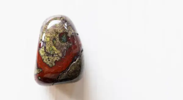 Ein polierter Stein mit roten und grünen Mustern, der an Drachenblut erinnert. Seine spirituelle Bedeutung liegt in Stärke und Schutz.