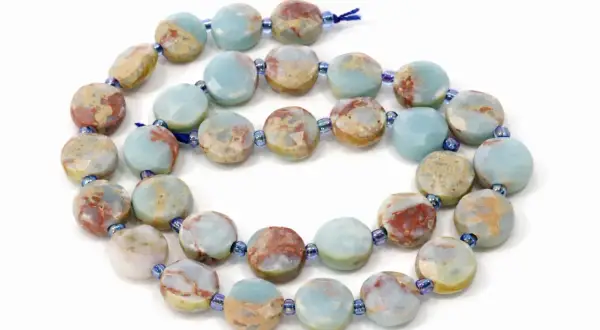 Kette aus flachen, facettierten Scheiben aus grauem Jaspis mit blauen und roten Einschlüssen. Die Wirkung dieses Steins soll beruhigend sein.