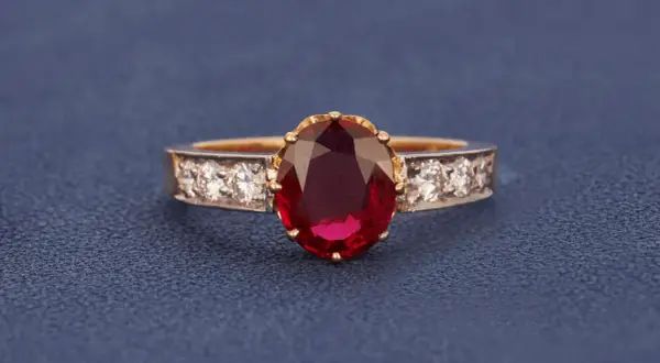 Ein Ring mit einem ovalen, tiefroten Edelstein, der an einen Rubin erinnert. Der Unterschied zwischen Granat und Rubin ist oft die Farbe.