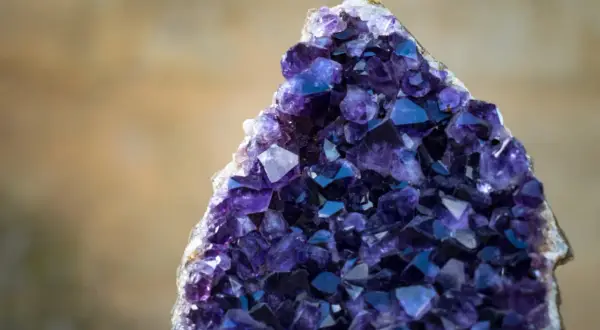 Ein glitzernder Amethyst Edelstein mit tiefvioletten Kristallen, der wie ein Schatz aus einer anderen Welt wirkt.