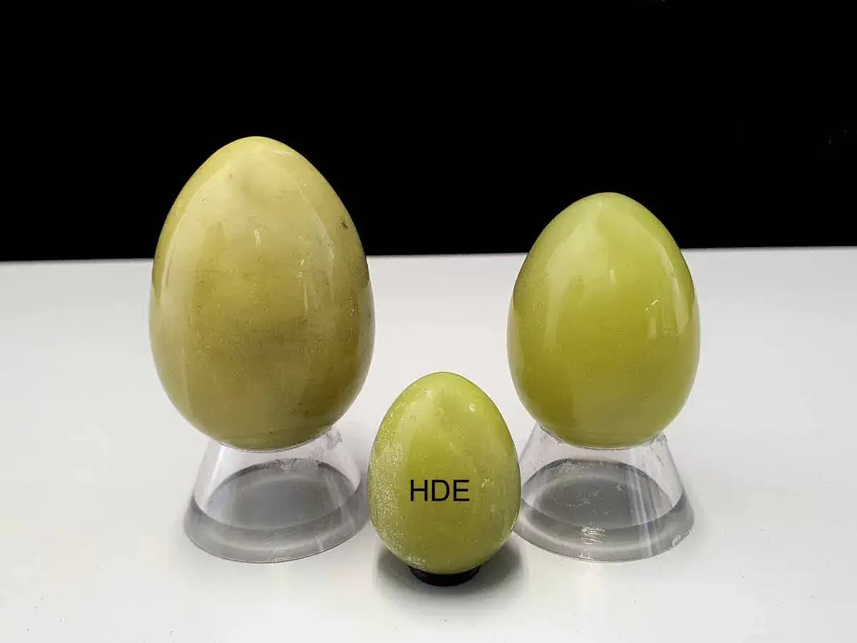 Drei polierte Serpentinsteine in Eiform, die die Bedeutung von Heilung und Erneuerung symbolisieren.