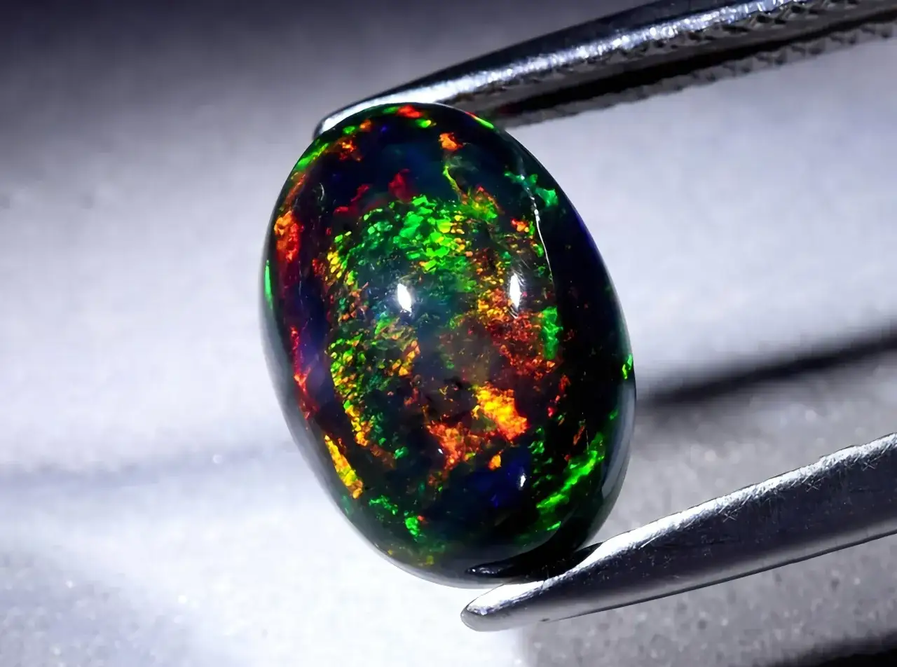 Ein faszinierender schwarzer Opal mit lebendigen Farbspielen von Grün, Rot und Gelb. Seine Wirkung ist magisch.