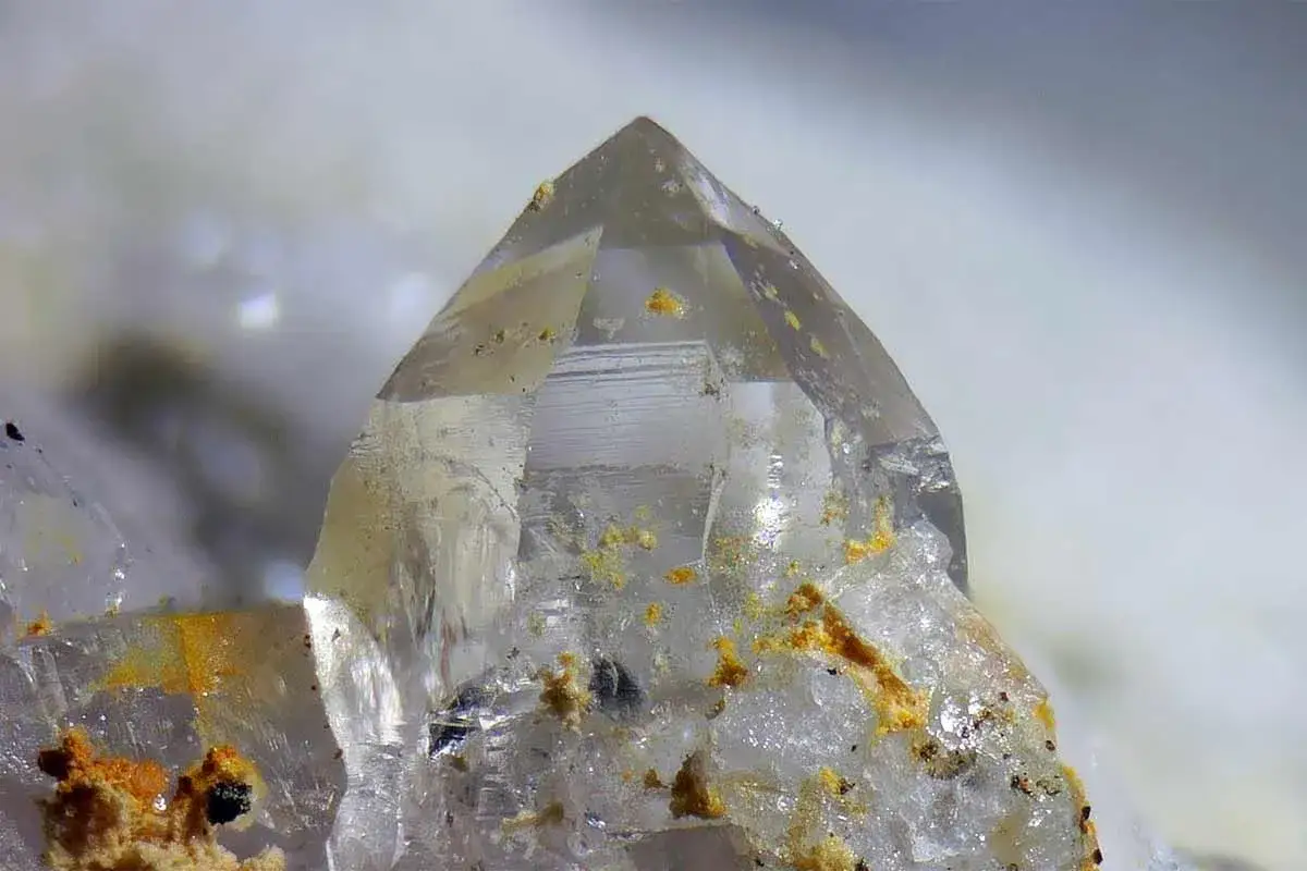 Nahaufnahme eines Bergkristalls mit gelben Einschl&uuml;ssen, die seine einzigartigen bergkristall eigenschaften unterstreichen.