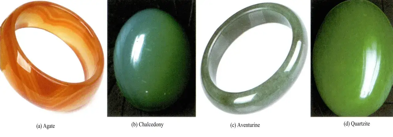 Vier Schmuckstücke: orangefarbener Achat, grüne Chalcedon-Kugel, Aventurin-Armreif und grüne Quarzit-Kugel. Der Name Jade hat eine tiefe Bedeutung.