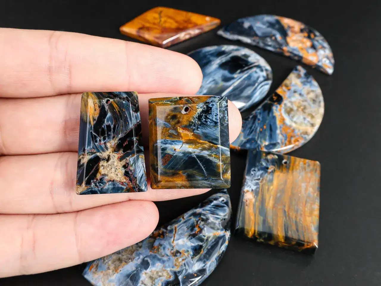 Zwei rechteckige Pietersit-Anhänger mit faszinierender blau-goldener Maserung, die die Wirkung dieses Steins auf die Intuition und Klarheit symbolisieren.