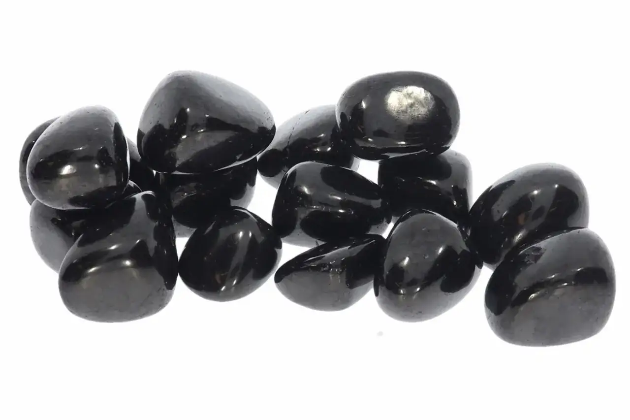 Gl&auml;nzende, polierte schwarze Steine, die an eine Sammlung von Obsidian erinnern. Ihre dunkle Farbe symbolisiert oft Schutz und St&auml;rke, was die tiefe schwarzer stein bedeutung unterstreicht.
