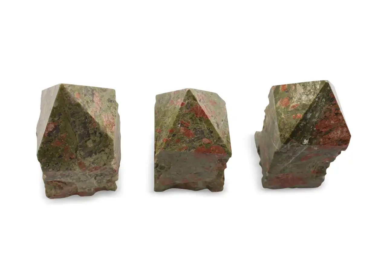 Drei facettierte Unakit-Kristalle mit Epidot-Einschl&uuml;ssen, die wie kleine Pyramiden aussehen.