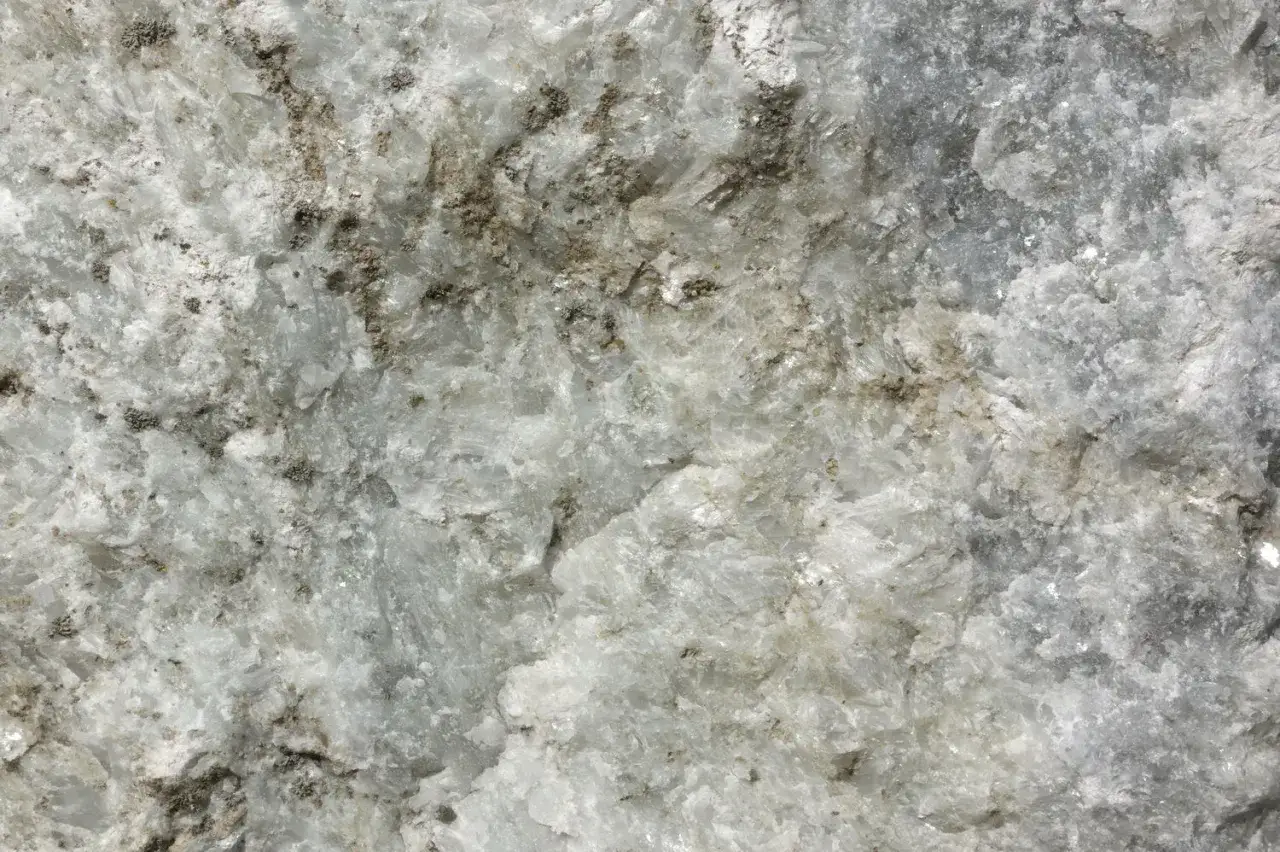 Nahaufnahme von wei&szlig;em Marmor mit grauen Einschl&uuml;ssen, die seine einzigartigen Marmor Eigenschaften zeigen.