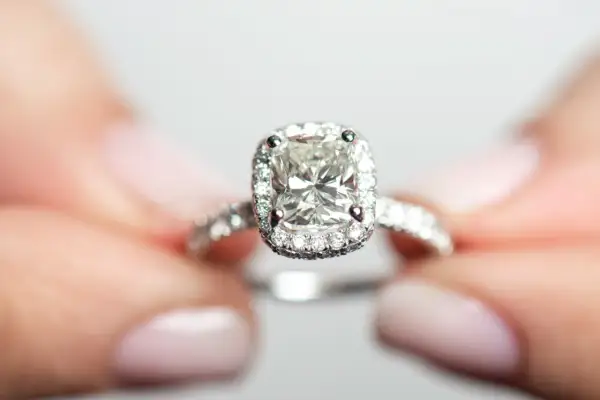 Ein funkelnder Verlobungsring mit einem großen Diamanten im Zentrum, umgeben von kleineren Steinen. Die Reinheit der Diamanten ist beeindruckend, fast wie eine Tabelle der Perfektion.