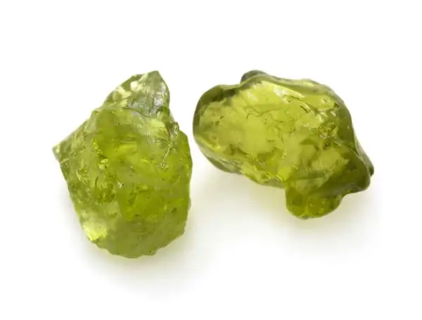 Zwei rohe Peridot-Kristalle in leuchtendem Grün. Ihre natürliche **Peridot Wirkung** soll angeblich das Herz öffnen und positive Energie fördern.
