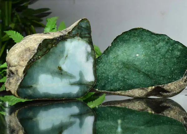 Zwei rohe Jade-Stücke, eines hellblau-grün, das andere tiefgrün. Die Jade-Name-Bedeutung spiegelt sich in ihrer Schönheit wider.