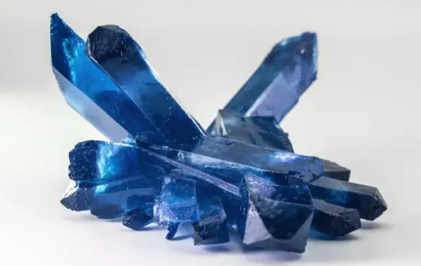 Ein Cluster tiefblauer Kristalle, die an gefrorene Eisspitzen erinnern. Die Bedeutung eines blauen Steins wird oft mit Ruhe und Klarheit assoziiert.